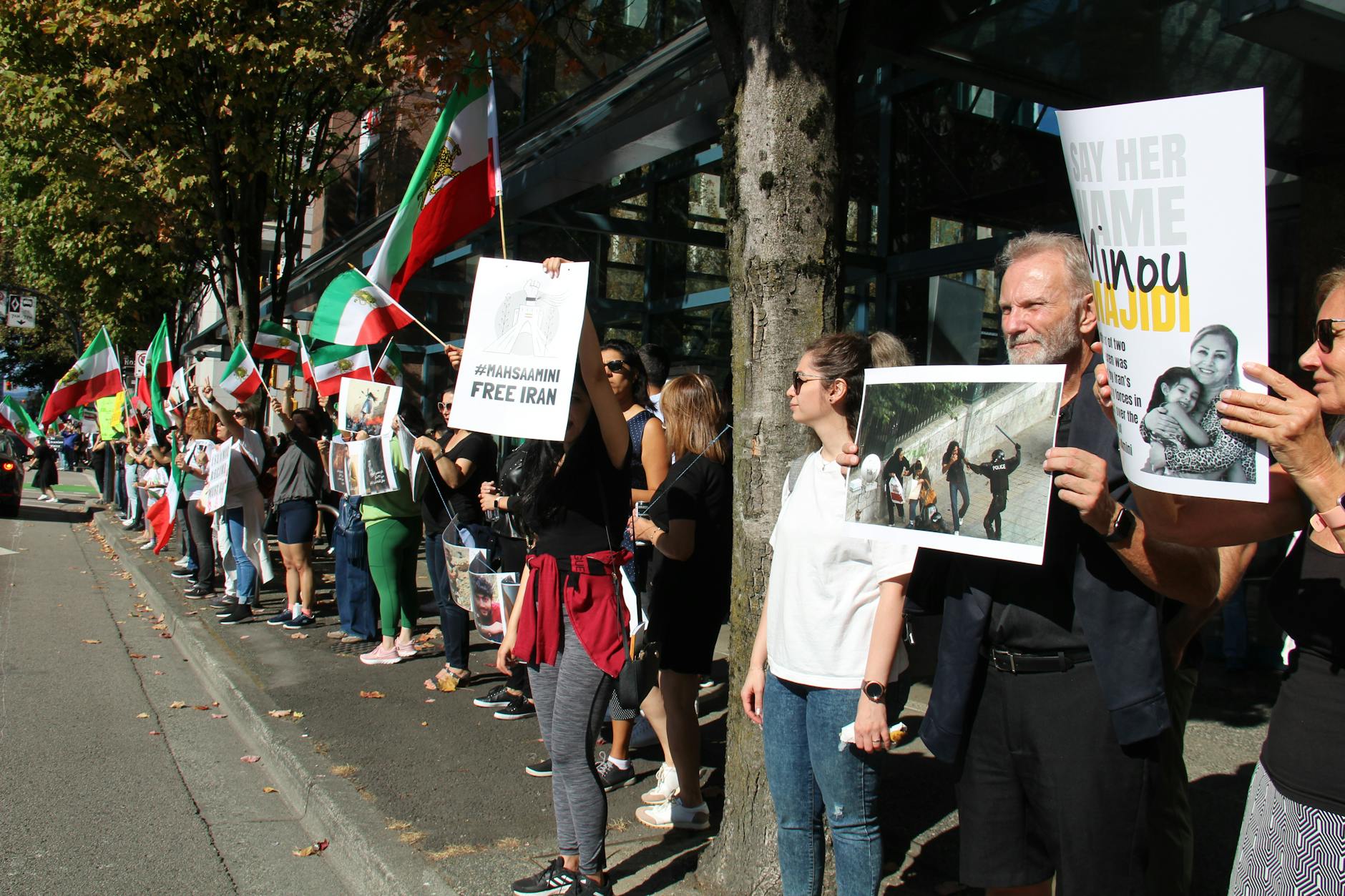 protesters standing on the roadside while holding placards