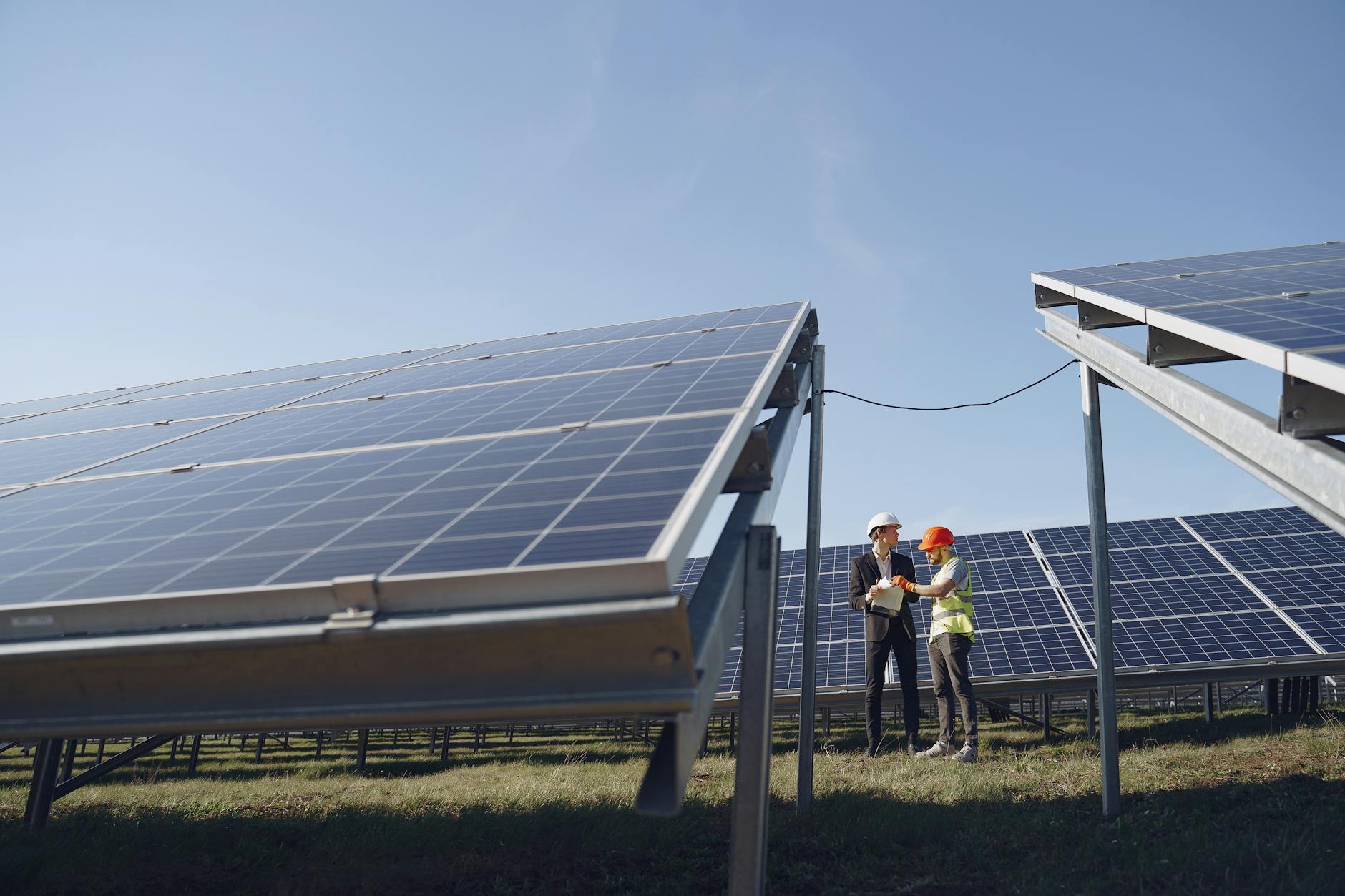 two electricians standing near the solar panels